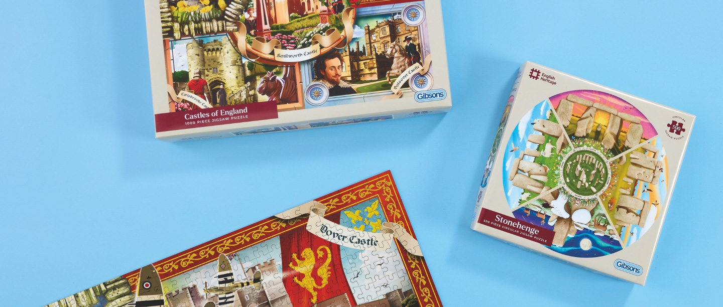 Castles of England puzzle box and Stonehenge puzzle box laid out on a light blue background.