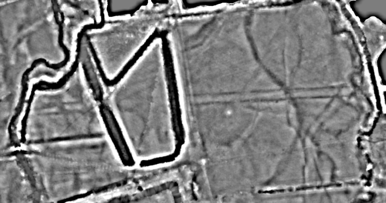 A black and white LiDAR image of two fields. It shows a strong black line running around the edge of the field on the right and faint black lines from the top to the bottom of the right field.