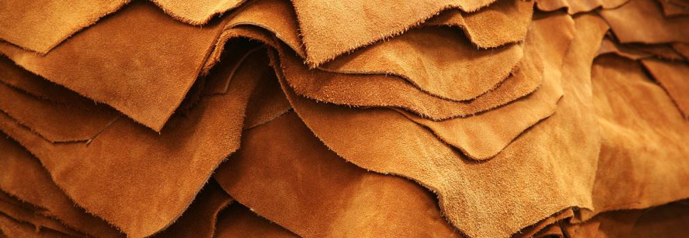 A pile of large sheets  of light brown leather.