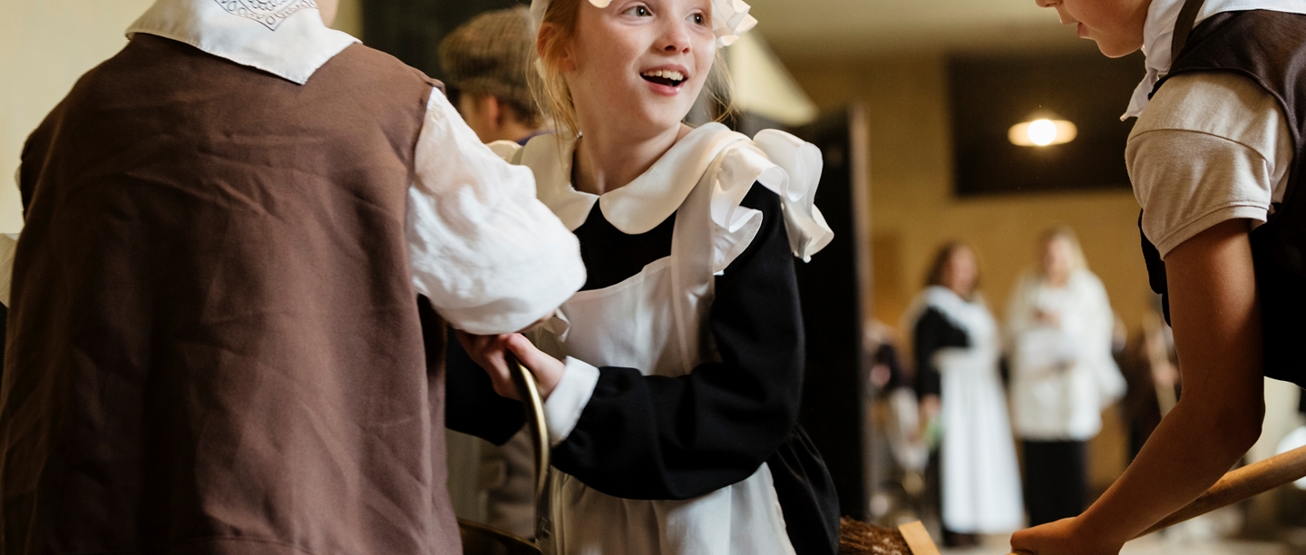 Boys and girls wearing Victorian servant costumes in the Coal Gallery at Audley End