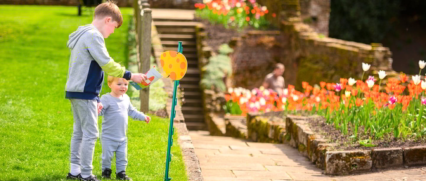 An older boy and a younger toddler take part in the Easter Adventure Quest at Eltham Palace.