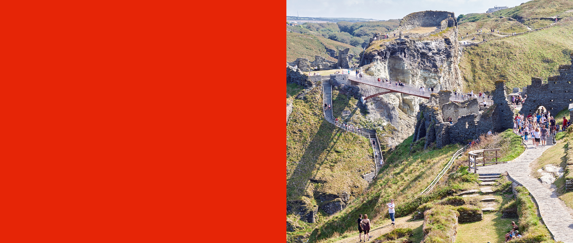 A view of Tintagel Castle showing the stone ruins, new bridge connecting the island to the mainland and steps up to the ruins
