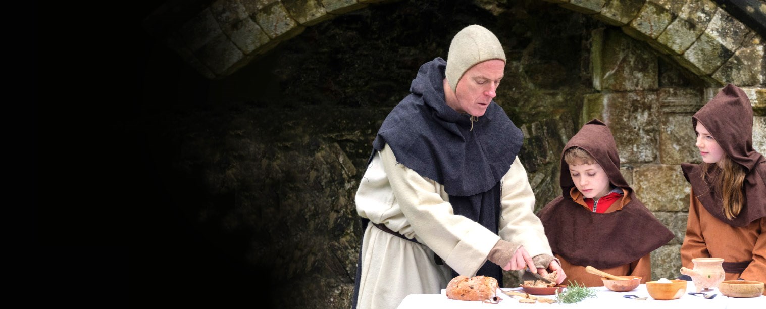 St Aelred showing young Members Emily and Sam how to make monks' porridge