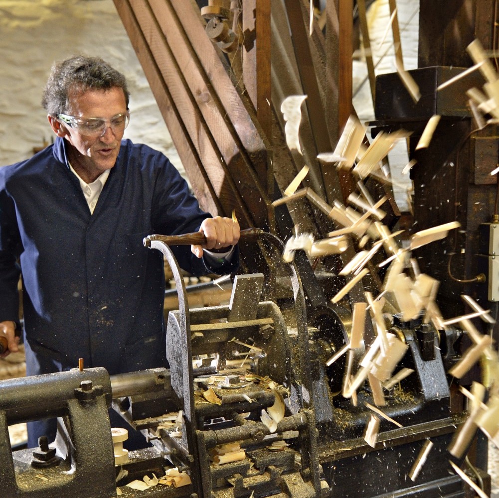 Photo of someone producing wooden bobbins at Stott Park Bobbin Mill