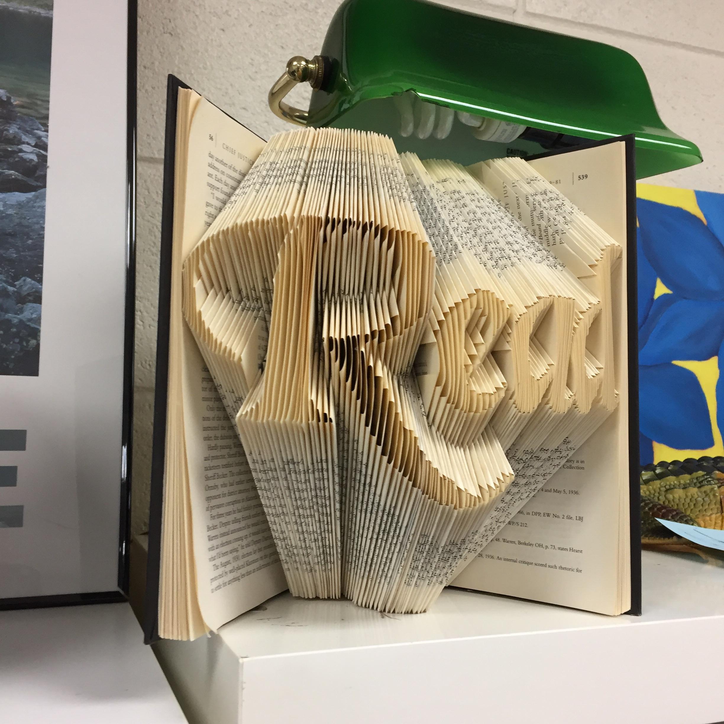 Photo of a book with its pages folded to produce the word 'Read'