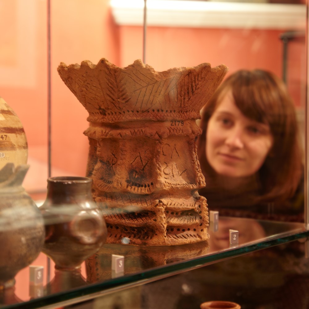 Photo of a visitor looking at a Roman object in the museum at Chesters Roman Fort