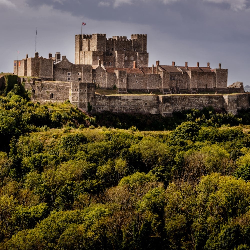 Photo of Dover Castle set amongst trees and greenery on Castle Hill