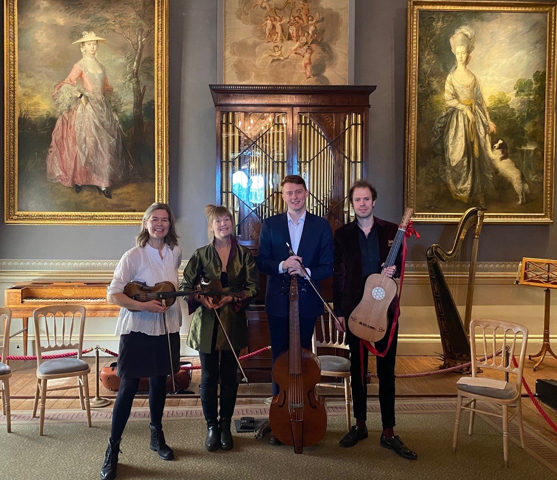 Photo of four people holding stringed instruments