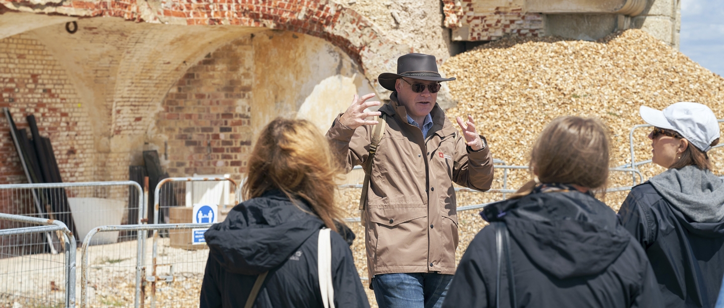 Photo of an English Heritage historian speaking to a group of people at Hurst Castle in Hampshire
