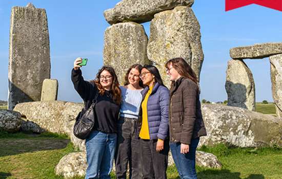 Image: group taking a selfie in front of Stonehenge