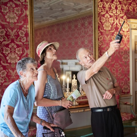 Photo of an English Heritage tour guide pointing out something to two visitors at Audley End House and Gardens in Essex