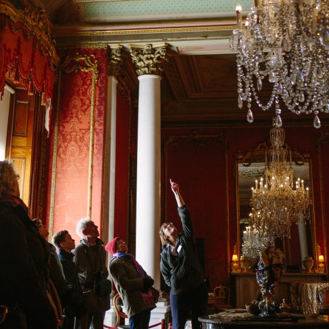 Photo of an English Heritage curator pointing out ceiling artwork to a group of visitors at Brodsworth Hall