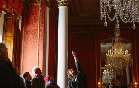 Photo of an English Heritage curator pointing out ceiling artwork to a group of visitors at Brodsworth Hall
