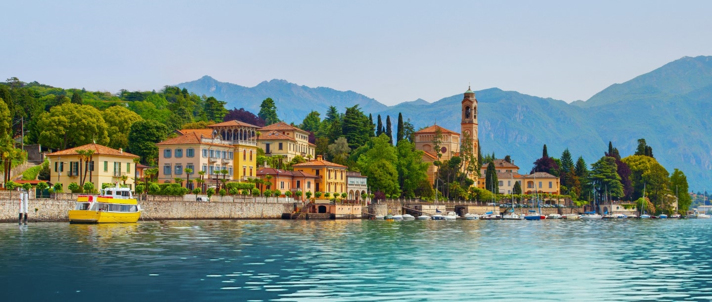 Photo of a picturesque town on the water with mountains in the background