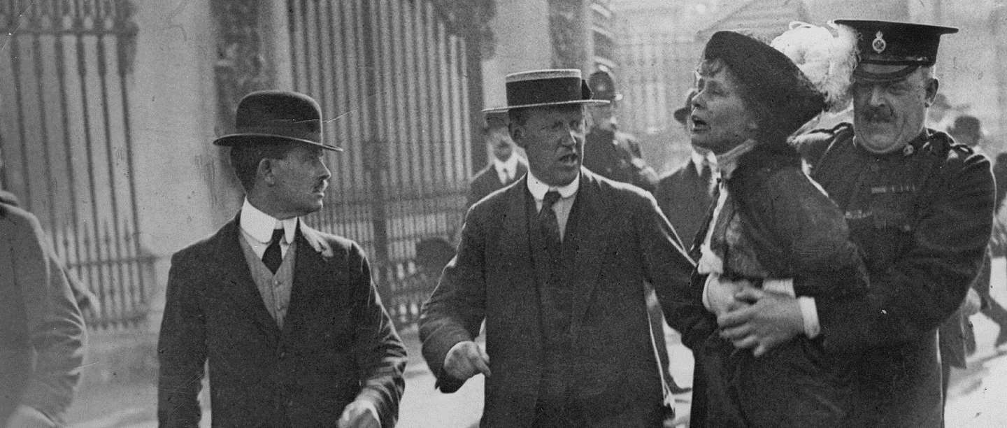 Black and white photograph of woman being restrained in London street