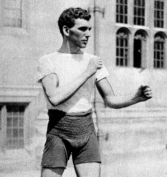 Grainy black and white photograph of boxer Harry Mallin, with fists raised