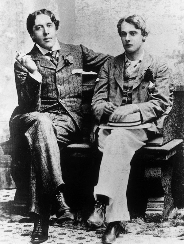 Black and white photograph of Oscar Wilde and Lord Alfred Douglas sitting next each other, Wilde smoking