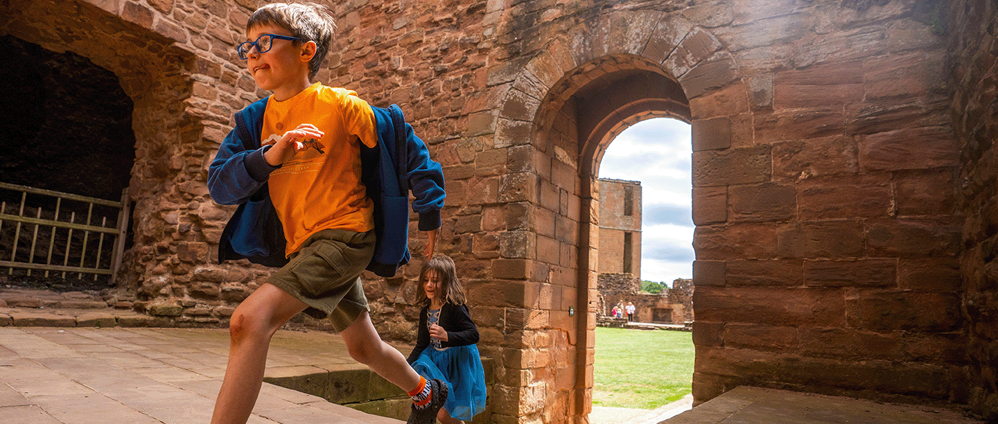 Photo of two children running through the remains of Kenilworth Castle in Warwickshire