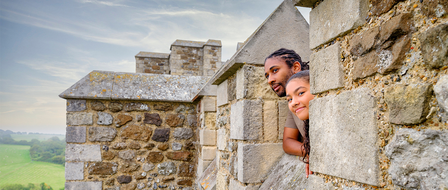 A dad and his daughter peep over the battlements at Dover Castle