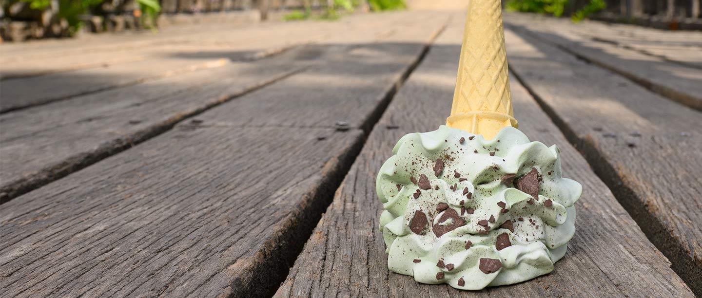 An ice cream sits upended on a wooden walkway