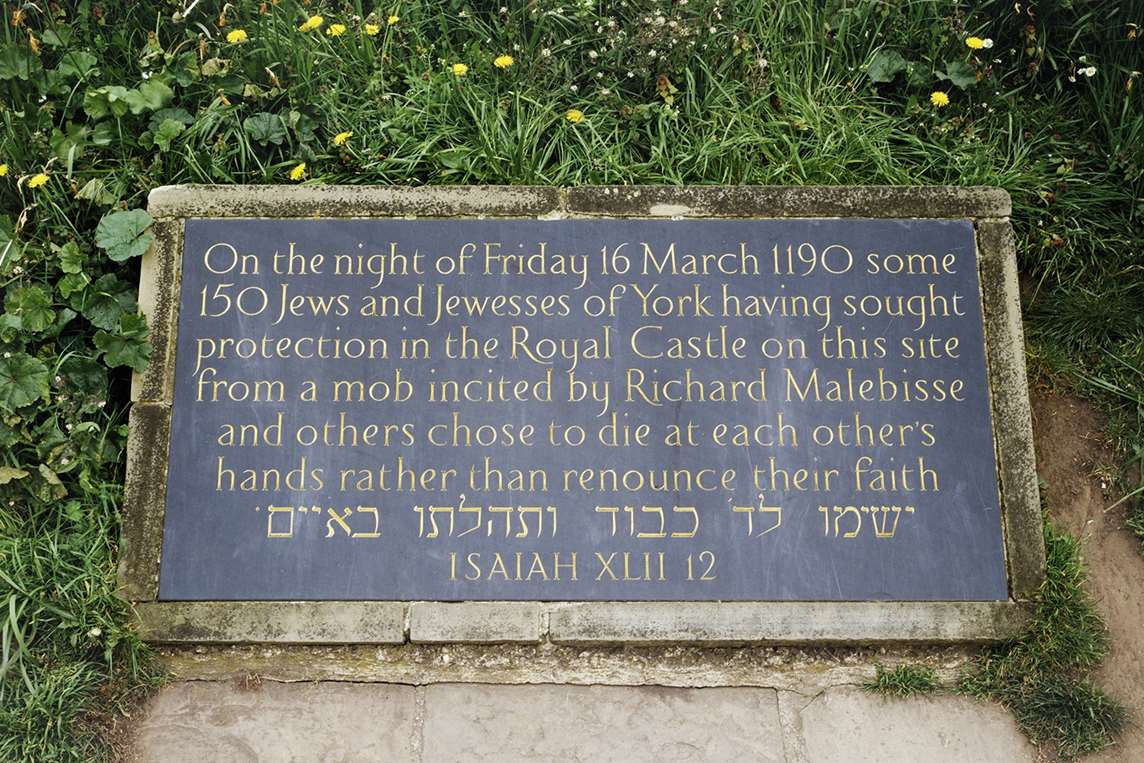 Commemorative plaque at the base of the mound of Clifford's Tower today Commemorative plaque at the base of the mound of Clifford's Tower today