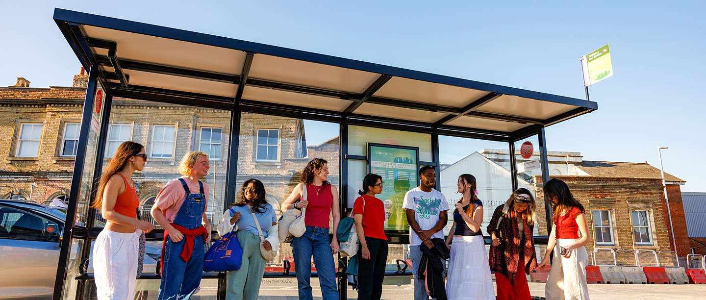 A group of people stood at a bus stop at Salisbury Bus Station.