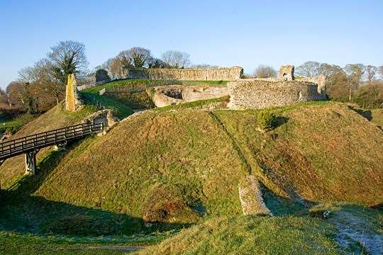 The inner bailey at Castle Acre ruined walls on the raised mound approached by a wooden bridge The inner bailey at Castle Acre ruined walls on the raised mound approached by a wooden bridge