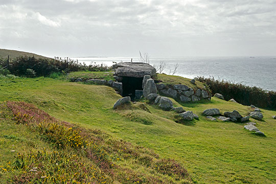 The stone entrance to Bants Carn with the ocean in the background