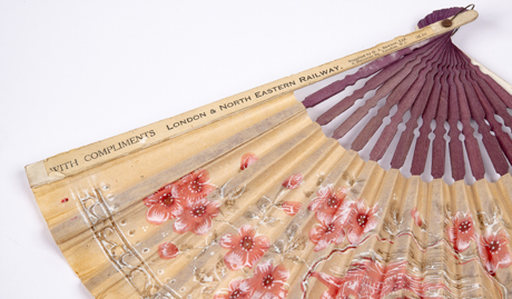 The fan, a single paper leaf mounted a l’Anglaise, is decorated with a Japanese style design. The fan was probably made in Japan, with the railway and retailer inscription supplied in England. 
