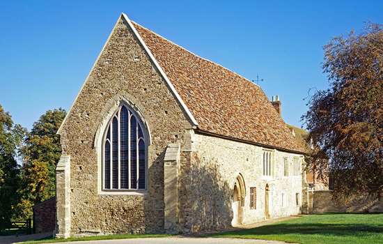 Exterior photo of Bushmead Priory surrounded by trees on a sunny day Exterior photo of Bushmead Priory surrounded by trees on a sunny day