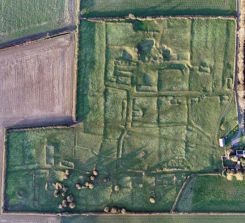 This vertical aerial photo of the village, taken in 2019, shows the medieval earthworks exceptionally clearly