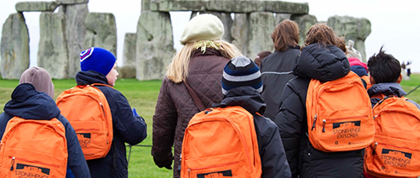 School children being led on a tour around Stonehenge