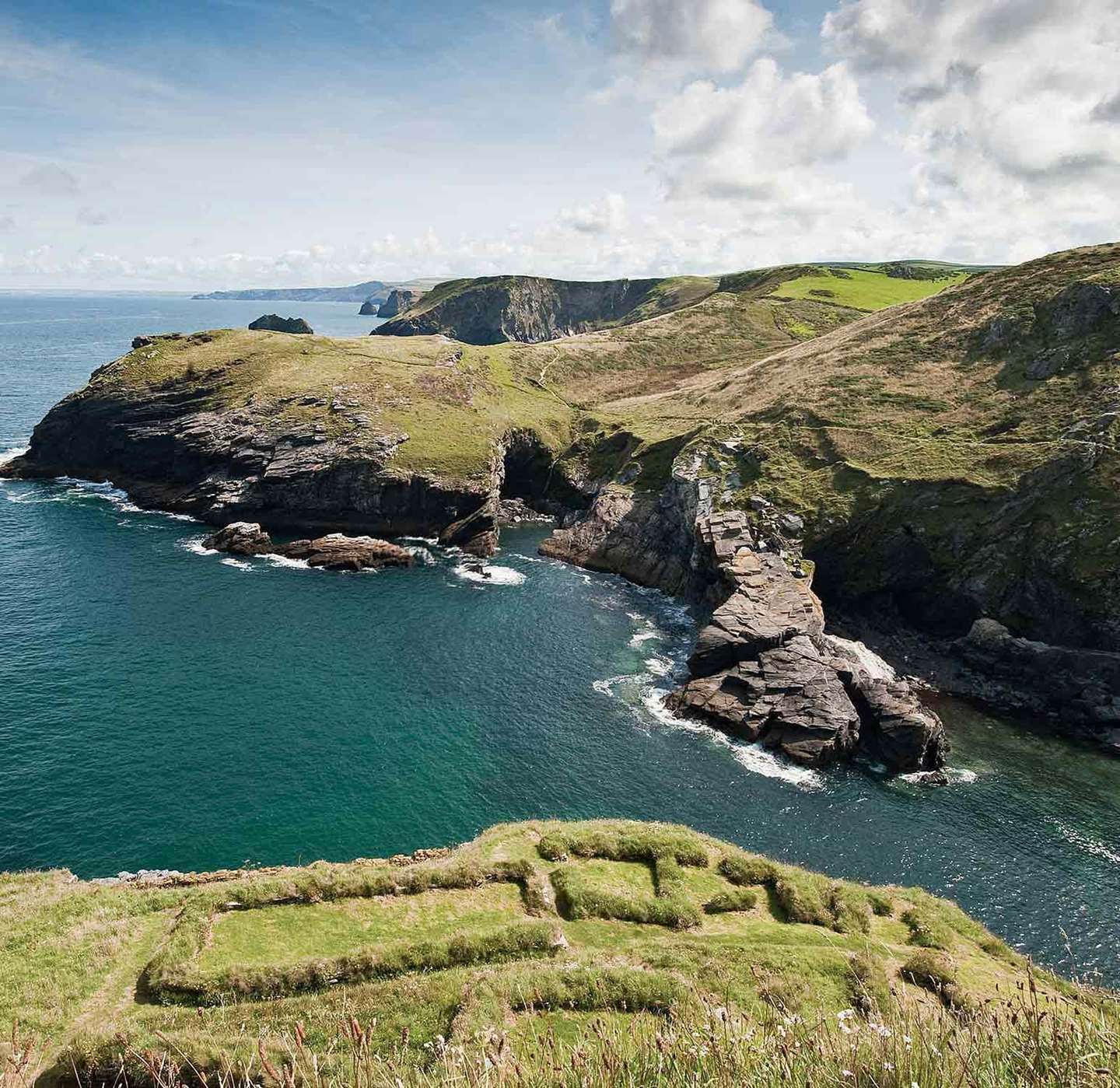 The early settlement remains on the eastern slopes of Tintagel island, looking across to the rocky headlands of the Cornish coast. The dramatic landscape was vividly described in Geoffrey of Monmouth’s ‘History of the Kings of Britain’