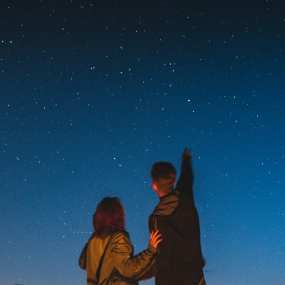 Two people looking up at a star-filled sky.