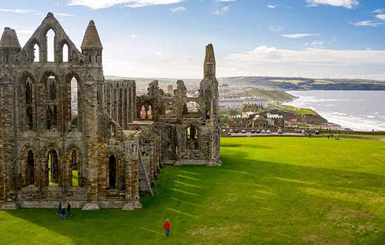 An aerial view of Whitby Abbey ruins with the town and coast in the background An aerial view of Whitby Abbey ruins with the town and coast in the background