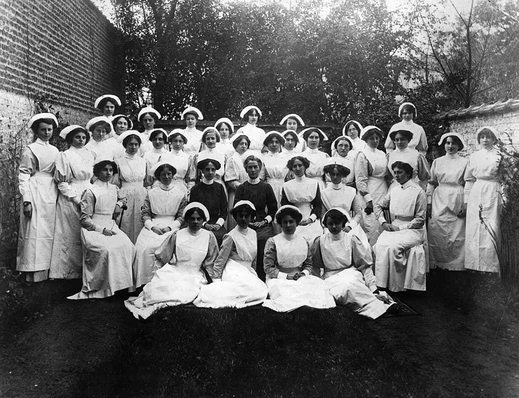 A black and white group portrait of Edith Cavell surrounded by several nurses in uniform