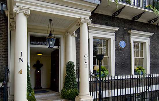 A grand town house with a blue plaque (to Nancy Astor) by the front door A grand town house with a blue plaque (to Nancy Astor) by the front door