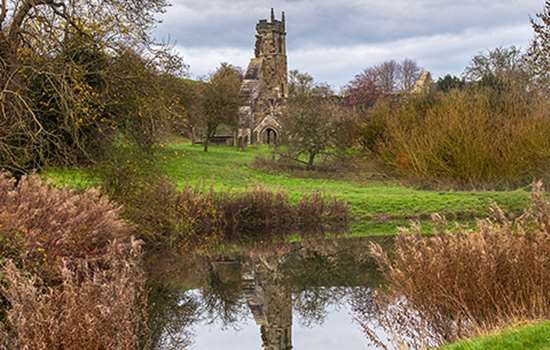 The ruined church at Wharram Percy seen the other side of a pond The ruined church at Wharram Percy seen the other side of a pond