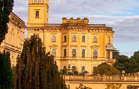 The clock tower and palatial looking Osborne glowing amber in the evening sun The clock tower and palatial looking Osborne glowing amber in the evening sun