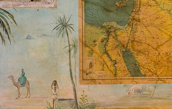 Close up of a wall featuring an image of a camel and some maps Close up of a wall featuring an image of a camel and some maps