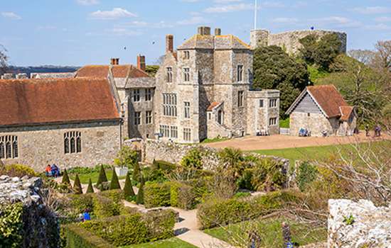 A small church with large buildings beyond surrounded by castle walls (Carisbrooke Castle) A small church with large buildings beyond surrounded by castle walls (Carisbrooke Castle)