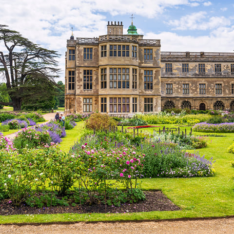 A view of Audley End House with the flower beds in the foreground.
