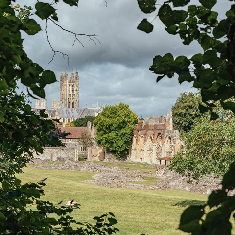 A view of St Augustine's Abbey through the tree leaves.