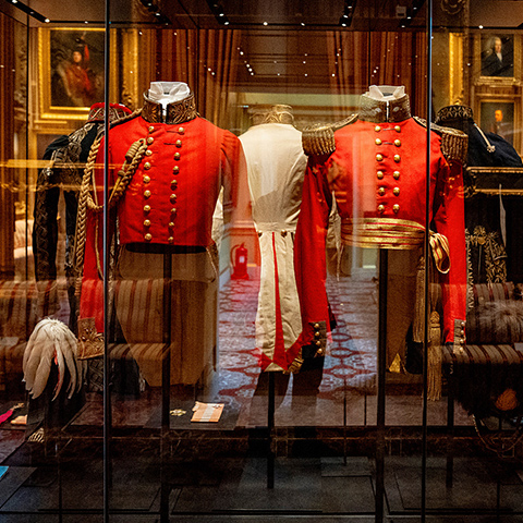 Red Georgian military costumes in a glass case