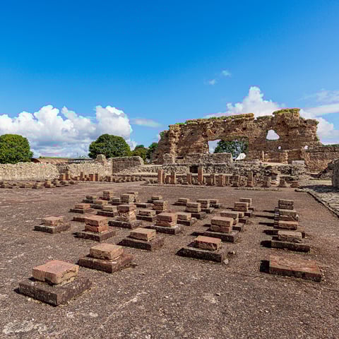 A view of the Roman stone walls and tiles at Wroxeter Roman City on a sunny day.