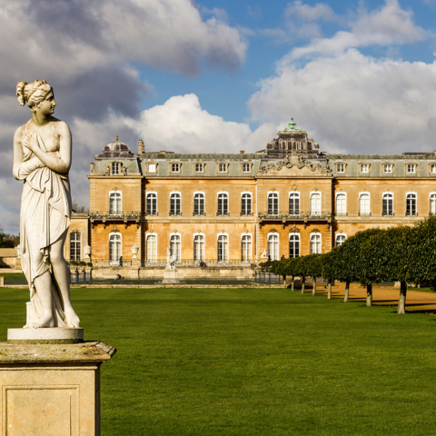 Statue in the foreground with the front of Wrest Park mansion in the background