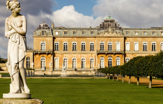 Statue in the foreground with the front of Wrest Park mansion in the background Statue in the foreground with the front of Wrest Park mansion in the background