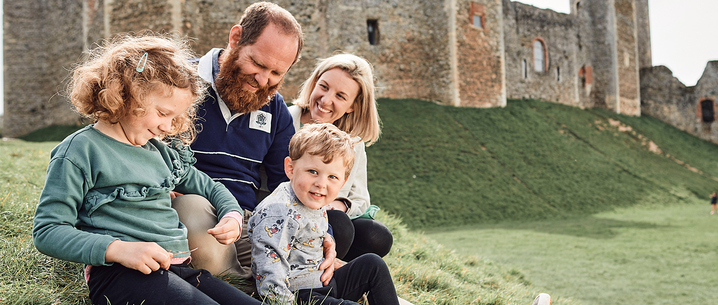 Image: a family sits in front of Framlingham Castle