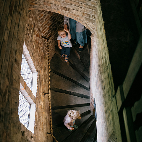 Bird's eye view looking down on two children walking down some stairs