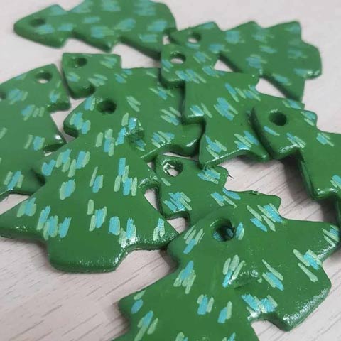 Several green painted wooden Christmas tree shapes.
